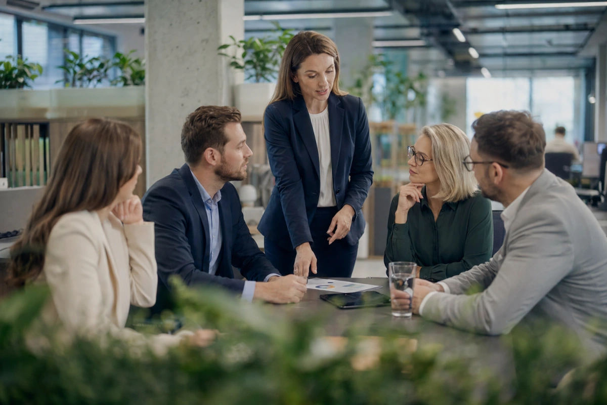 Pracownicy przy stole konferencyjnym w polskim biurze — PPK Pracownicze Plany Kapitałowe, czy warto się zapisać.